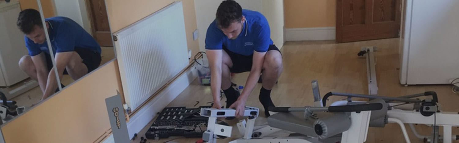 Removals crew member dismantling furniture before a house move Removals crew member dismantling furniture before a house move